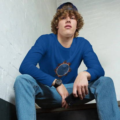 A young man wearing a true royal blue Xigfireon long sleeve graphic tee featuring the Eclipsed iteration of the Morning Star Fire Celtic knot design, inspired by the 2023 Annular Solar Eclipse.