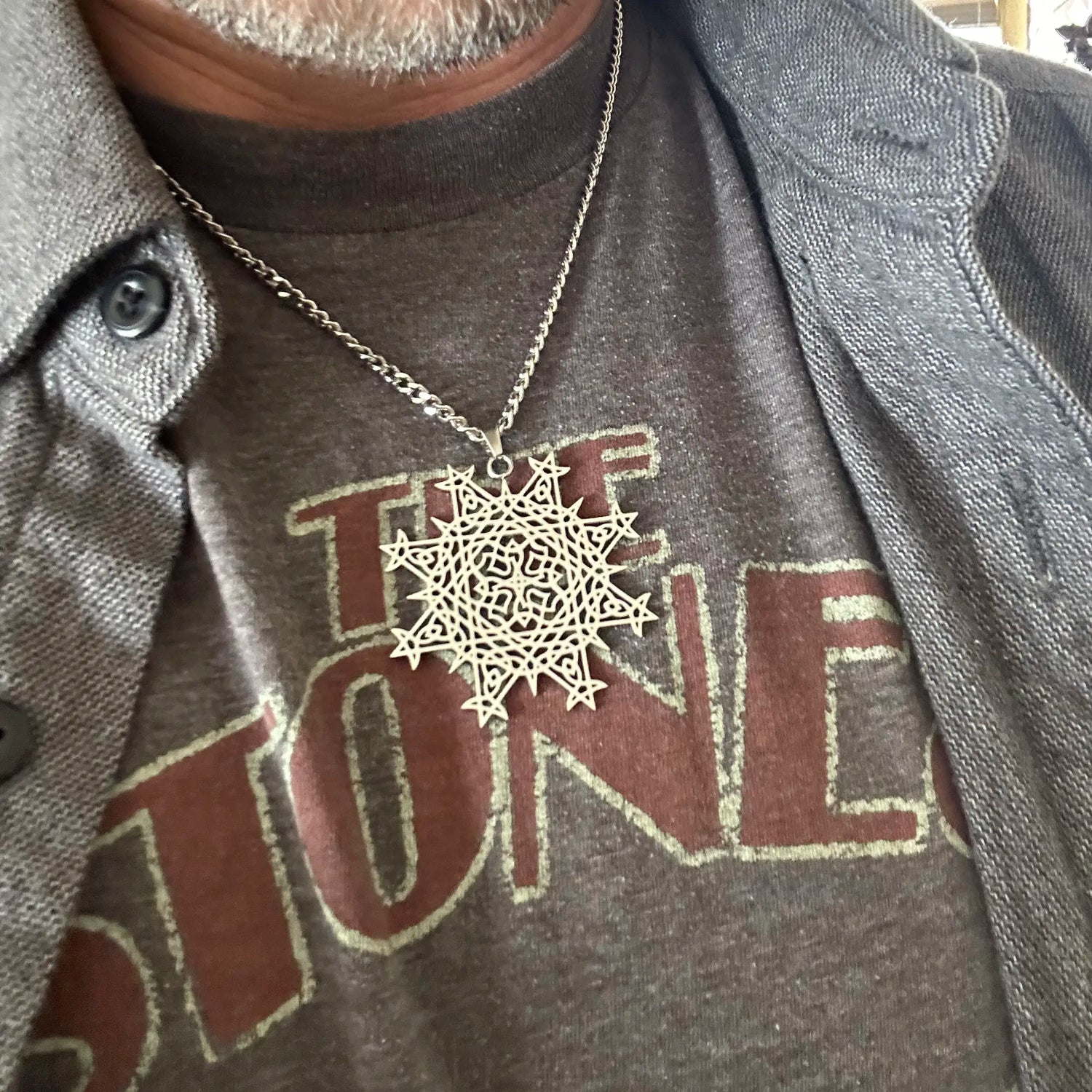 Necklace with a Morning Star Fire Celtic knot pendant, worn by a man with a Rolling Stones t-shirt.