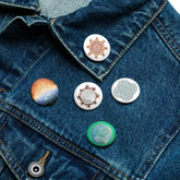 A jean jacket with 5 assorted 1.25 inch pin-back buttons featuring Morning Star Fire, Reach Of The Spirit, and Derivation II Celtic knot designs.