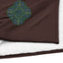 A close-up view of a fireside brown Xigfireon sherpa blanket embroidered with the Living Colour iteration of the Reach Of The Spirit Celtic knot design.