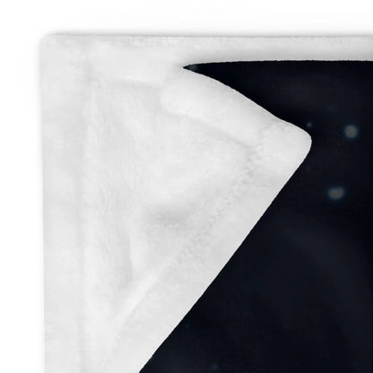 A close-up of the corner of a 60 inch by 80 inch Xigfireon throw blanket featuring the Eclipsed iteration of the Morning Star Fire Celtic knot design, showing its soft, silky fibers.