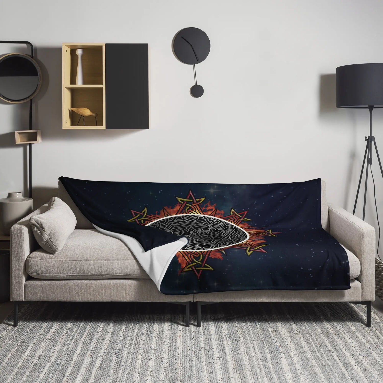 A sofa covered by a 60 inch by 80 inch Xigfireon throw blanket featuring the Eclipsed iteration of the Morning Star Fire Celtic knot design. Inspired by the 2023 Annular Solar Eclipse.