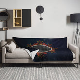 A sofa covered by a 60 inch by 80 inch Xigfireon throw blanket featuring the Eclipsed iteration of the Morning Star Fire Celtic knot design. Inspired by the 2023 Annular Solar Eclipse.