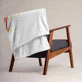 A chair covered by a 50 inch by 60 inch Xigfireon throw blanket featuring the Fire Colour Flat iteration of the Morning Star Fire Celtic knot design. The Morning Star Fire Celtic knot represents the Sun.