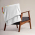 A chair covered by a 50 inch by 60 inch Xigfireon throw blanket featuring the Fire Colour Flat iteration of the Morning Star Fire Celtic knot design. The Morning Star Fire Celtic knot represents the Sun.