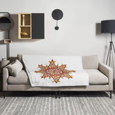A sofa covered by a 50 inch by 60 inch Xigfireon throw blanket featuring the Fire Colour iteration of the Morning Star Fire Celtic knot design. The Morning Star Fire Celtic knot represents the Sun.