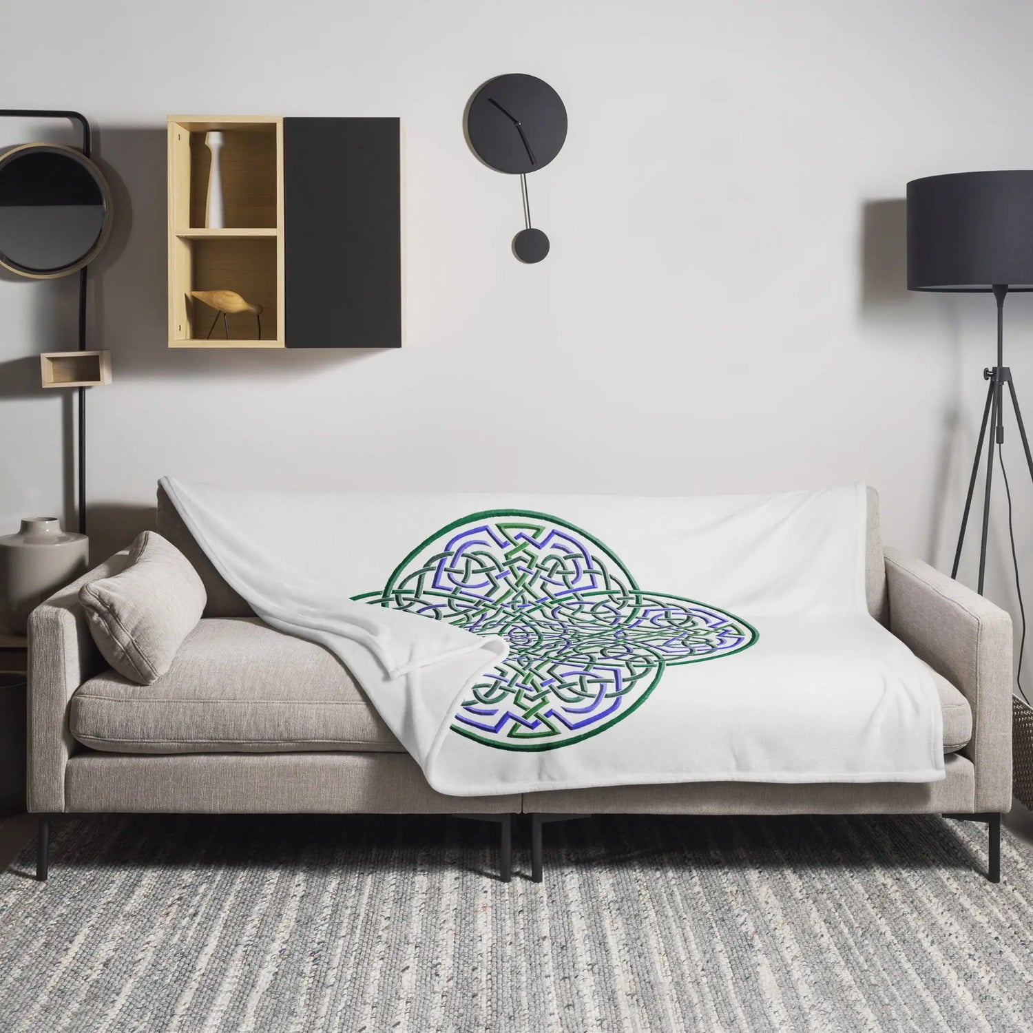 A sofa covered by a 60 inch by 80 inch Xigfireon throw blanket featuring the original Living Colour iteration of the Reach Of The Spirit Celtic knot design. The Reach Of The Spirit Celtic knot represents the Earth.