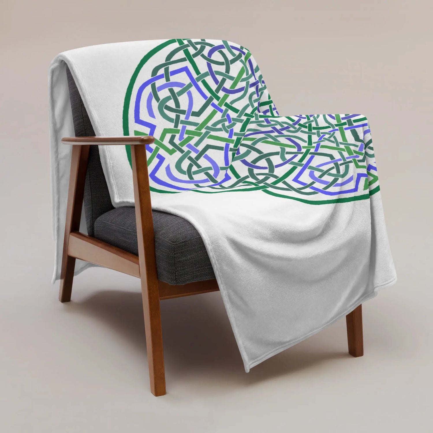 A chair covered by a 60 inch by 80 inch Xigfireon throw blanket featuring the Living Colour Flat iteration of the Reach Of The Spirit Celtic knot design. The Reach Of The Spirit Celtic knot represents the Earth.
