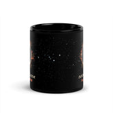 11oz black ceramic mug showing a starry space design with white stars and small orange celestial illustrations seen on the left and right sides, shown on a clean white background.