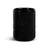 15oz black ceramic mug showing a starry space design with white stars and small orange celestial illustrations seen on the left and right sides, shown on a clean white background.