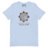 A light blue short-sleeve t-shirt by Xigfireon with a central graphic of a solar eclipse. The graphic features a detailed Celtic knot Sun surrounded by rays with the Spanish text &