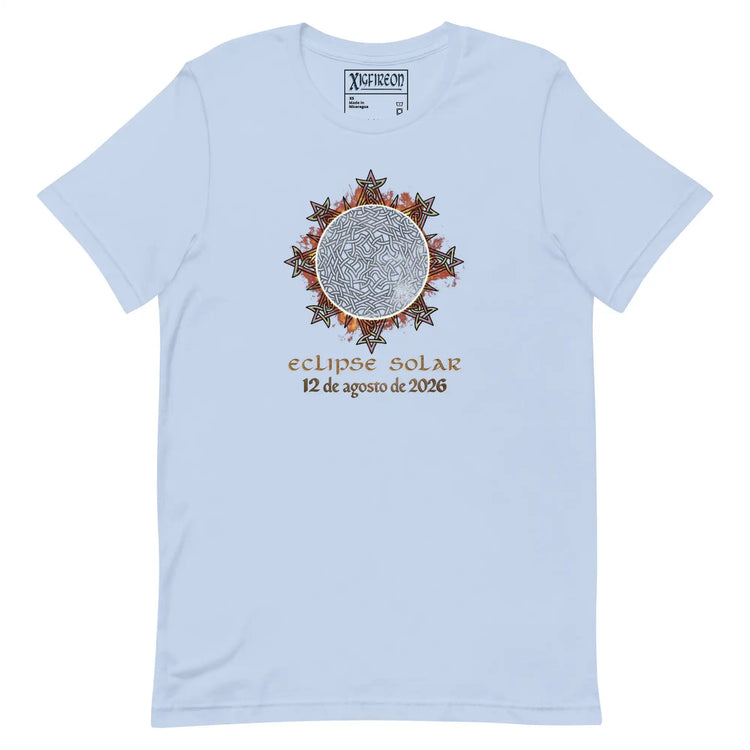 A light blue short-sleeve t-shirt by Xigfireon with a central graphic of a solar eclipse. The graphic features a detailed Celtic knot Sun surrounded by rays with the Spanish text &