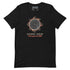 A black short-sleeve t-shirt with a graphic of a solar eclipse by Xigfireon. The graphic features a detailed Sun design with red and orange leaf-like accents, followed by the Spanish text &
