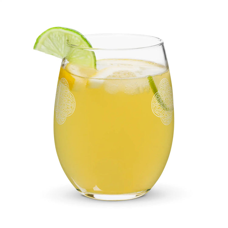 The back side of a stemless wine glass, filled with a refreshing cocktail, featuring the Solid White iteration of the Reach Of The Spirit Celtic knot design. The Reach Of The Spirit Celtic knot is an Earth symbol.