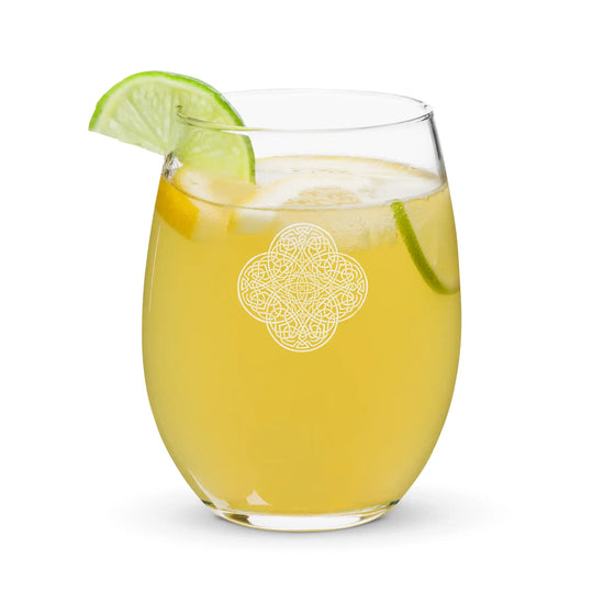 The front side of a stemless wine glass, filled with a refreshing cocktail, featuring the Solid White iteration of the Reach Of The Spirit Celtic knot design. The Reach Of The Spirit Celtic knot is an Earth symbol.
