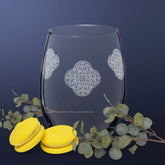 The front side of a stemless wine glass featuring the Solid White iteration of the Reach Of The Spirit Celtic knot design.