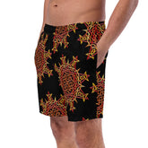 A young man wearing a pair of Xigfireon graphic swim trunks featuring the Fire Colour Black patterned series of the Morning Star Fire Celtic knot design.