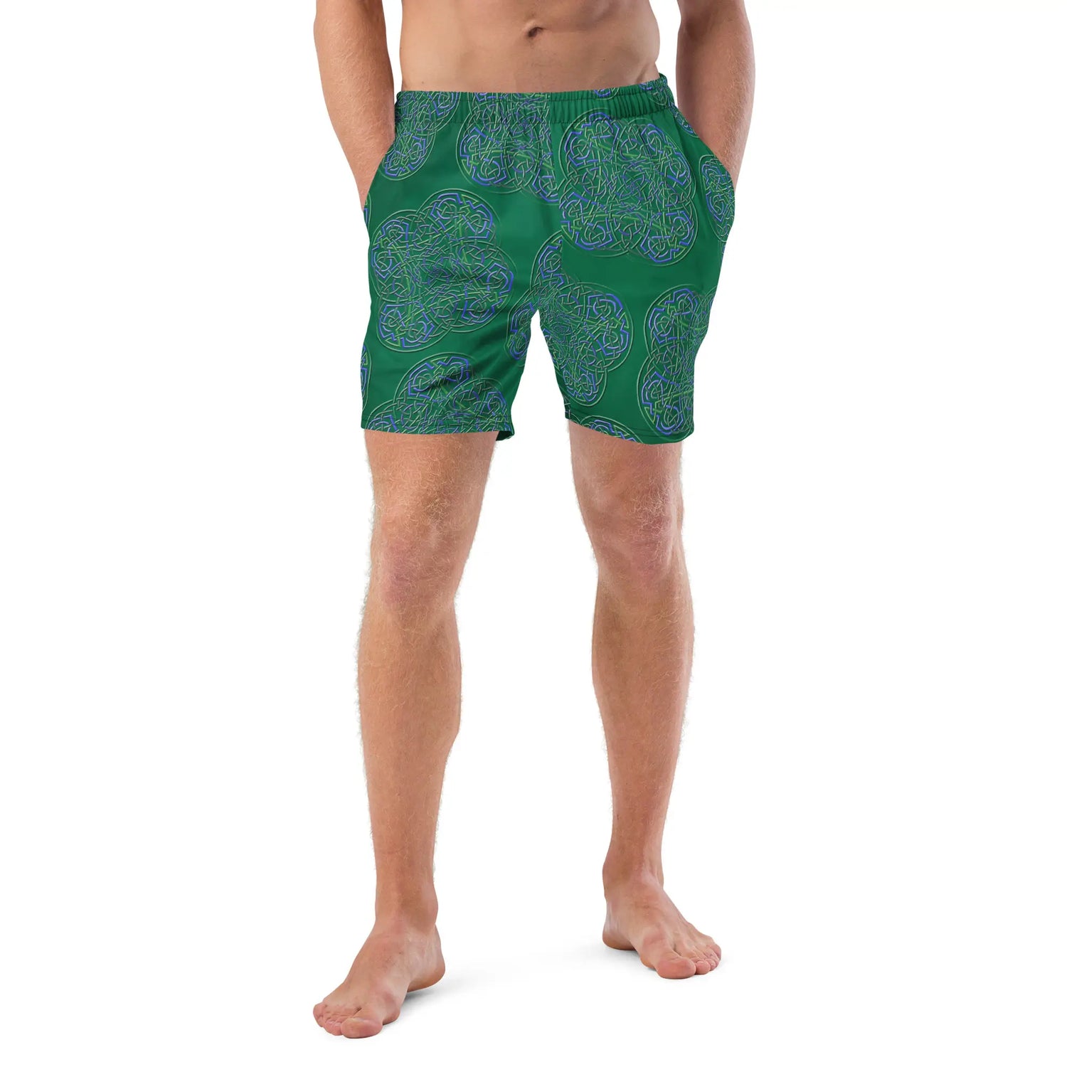 A young man wearing a pair of Xigfireon graphic swim trunks featuring the Living Colour Forest patterned series of the Reach Of The Spirit Celtic knot design.