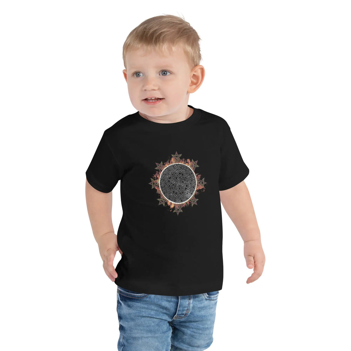 A young boy shown wearing a black Xigfireon toddler graphic t-shirt featuring the Eclipsed iteration of the Morning Star Fire Celtic knot design. The Morning Star Fire Celtic knot represents the Sun.