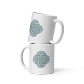 A stack of two Xigfireon white ceramic 11oz mugs featuring the Living Colour iteration of the Reach Of The Spirit Celtic knot design. This Celtic knot symbolizes Mother Earth.