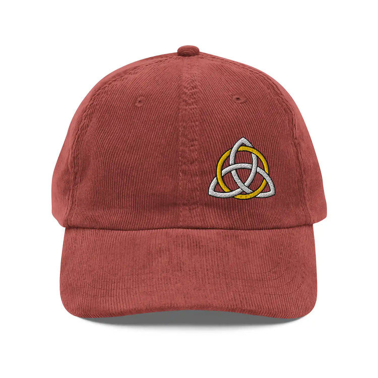 The front side of a burgundy Xigfireon vintage corduroy cap embroidered with a White & Gold Celtic Trinity Knot, offset to the left.
