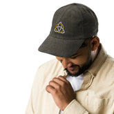 A young man wearing an olive green Xigfireon vintage corduroy cap embroidered with a White & Gold Celtic Trinity Knot.