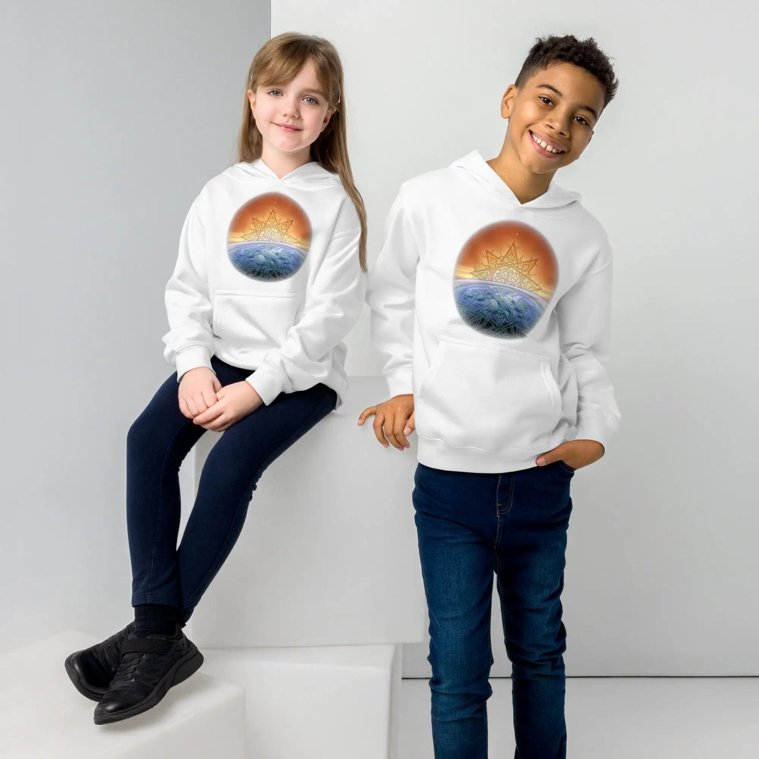 A girl and a boy, each wearing a white graphic hoodie featuring the `Derivation II` Celtic knots merger design.