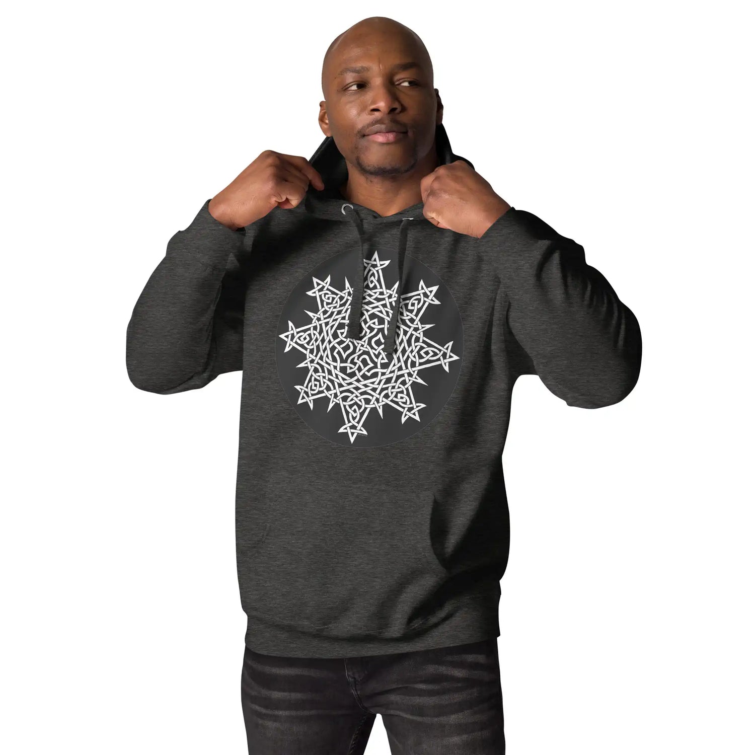 A young man wearing a charcoal heather Xigfireon graphic hoodie featuring the Black & White Circle iteration of the `Morning Star Fire` Celtic knot design. This Celtic knot symbolizes the Sun.