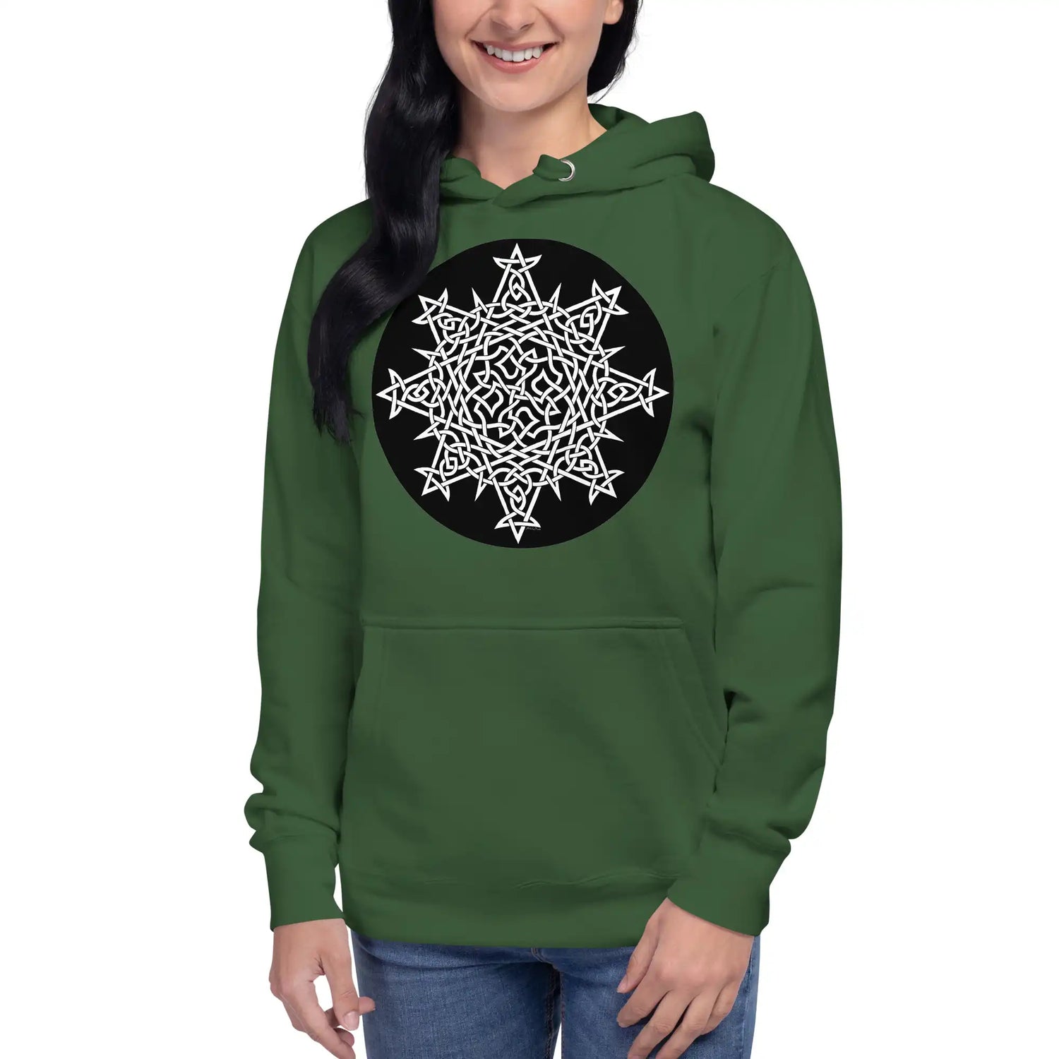 A young woman wearing a forest green Xigfireon graphic hoodie featuring the Black & White Circle iteration of the `Morning Star Fire` Celtic knot design. The `Morning Star Fire` Celtic knot represents the Sun.