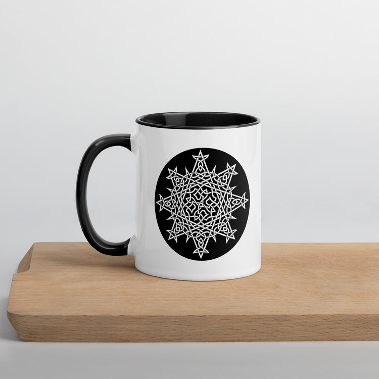 A Xigfireon white ceramic 11oz mug featuring the Black & White Circle iteration of the `Morning Star Fire` Celtic knot design, with black handle and inside. This Celtic knot symbolizes Father Sun.