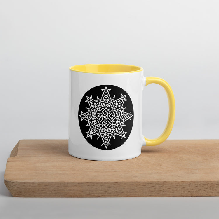 A Xigfireon white ceramic 11oz mug featuring the Black & White Circle iteration of the `Morning Star Fire` Celtic knot design, with yellow handle and inside. This Celtic knot symbolizes Father Sun.