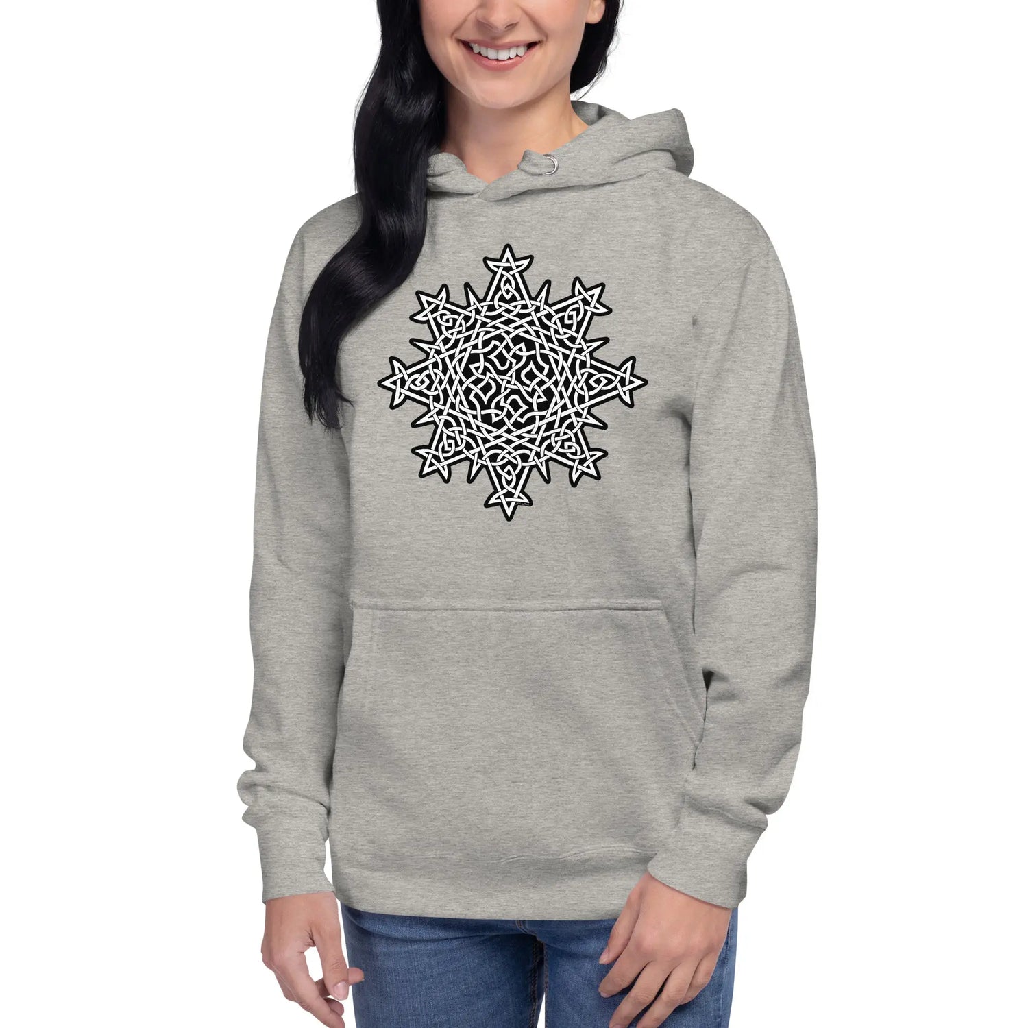 A young woman wearing a carbon grey Xigfireon graphic hoodie featuring the Black & White Solid iteration of the `Morning Star Fire` Celtic knot design. This Celtic knot symbolizes the Sun.