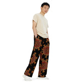 A young man wearing a pair of Xigfireon graphic wide leg pants featuring the Fire Colour Black patterned series of the `Morning Star Fire` Celtic knot design.