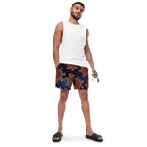 A young man wearing a pair of Xigfireon graphic swim trunks featuring the Fire Colour Cosmos patterned series of the `Morning Star Fire` Celtic knot design.