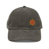 The front side of an olive green Xigfireon vintage corduroy cap embroidered with the Fire Colour iteration of the `Morning Star Fire` Celtic knot design offset to the left.