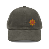 The front side of an olive green Xigfireon vintage corduroy cap embroidered with the Fire Colour iteration of the `Morning Star Fire` Celtic knot design offset to the left.