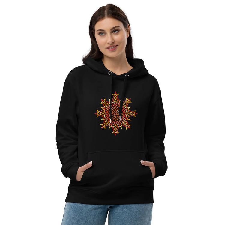 A young woman wearing a black Xigfireon graphic eco-friendly hoodie featuring the Fire Colour iteration of the `Morning Star Fire` Celtic knot design. The `Morning Star Fire` Celtic knot symbolizes the Sun.