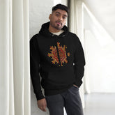 A young man wearing a black Xigfireon graphic hoodie featuring the Fire Colour iteration of the `Morning Star Fire` Celtic knot design. The `Morning Star Fire` Celtic knot represents the Sun.