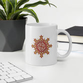 An office desktop displaying a Xigfireon white ceramic 11oz mug featuring the Fire Colour iteration of the `Morning Star Fire` Celtic knot design. This Celtic knot symbolizes Father Sun.