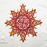 A close-up view of a white Xigfireon graphic t-shirt featuring a screen printed version of the Fire Colour iteration of the `Morning Star Fire` Celtic knot design.