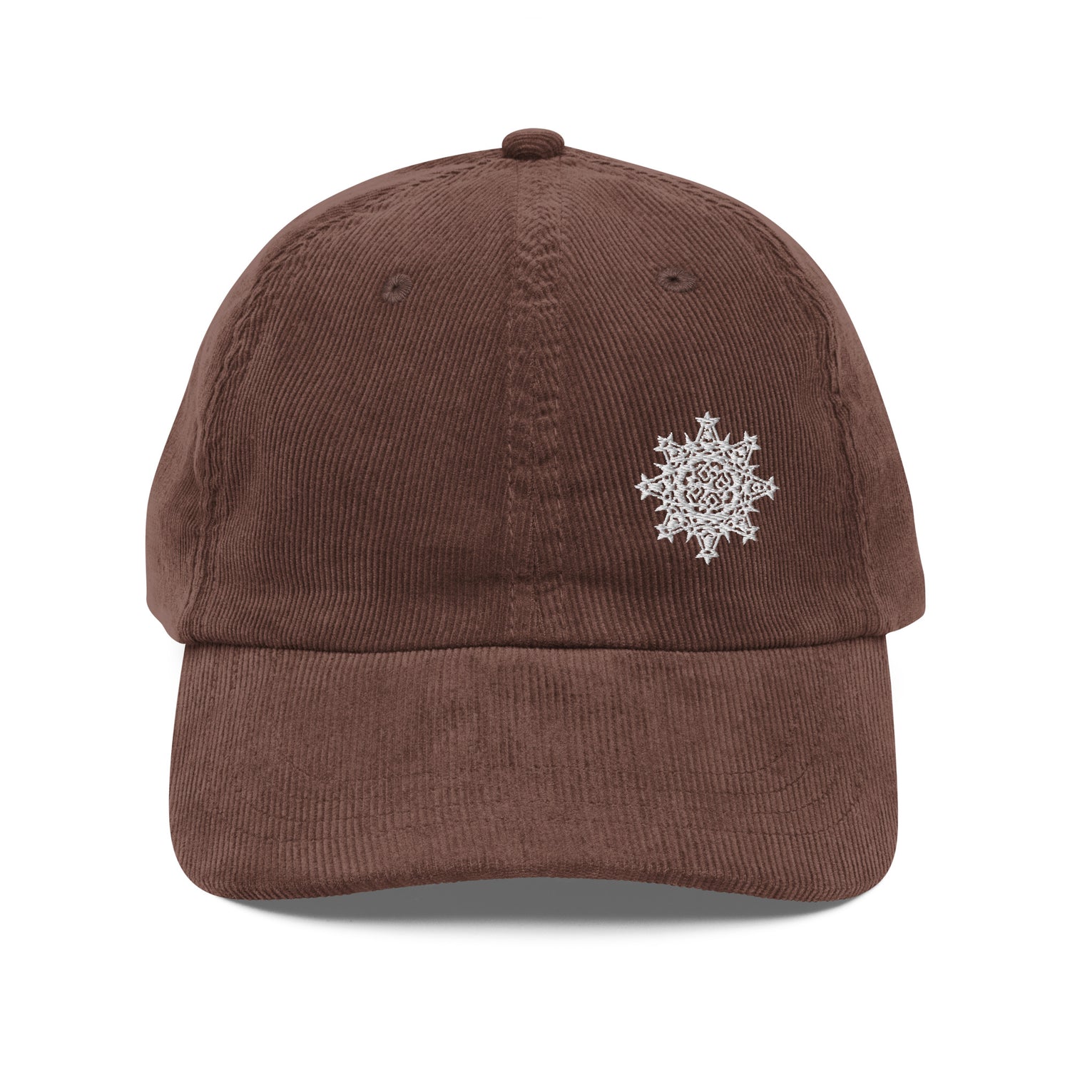 The front side of a brown Xigfireon vintage corduroy cap embroidered with the White iteration of the `Morning Star Fire` Celtic knot design offset to the left.