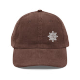 The front side of a brown Xigfireon vintage corduroy cap embroidered with the White iteration of the `Morning Star Fire` Celtic knot design offset to the left.