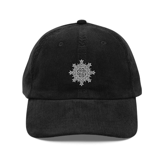 The front side of a black Xigfireon vintage corduroy cap embroidered with the White iteration of the `Morning Star Fire` Celtic knot design.