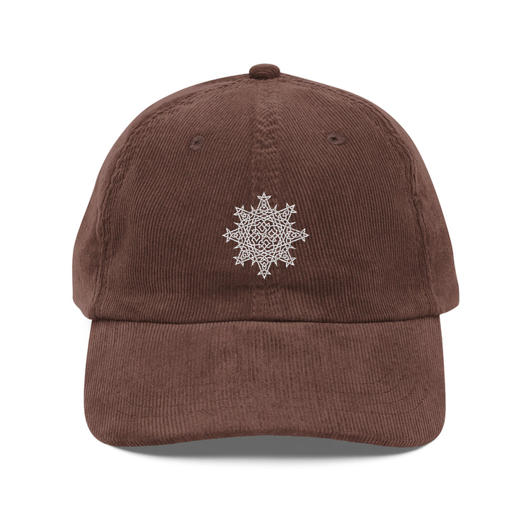 The front side of a brown Xigfireon vintage corduroy cap embroidered with the White iteration of the `Morning Star Fire` Celtic knot design.