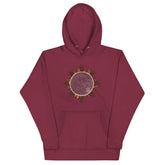 A maroon Xigfireon graphic hoodie featuring the Eclipsed iteration of the `Morning Star Fire` Celtic knot design, inspired by the 2023 Annular Solar Eclipse.