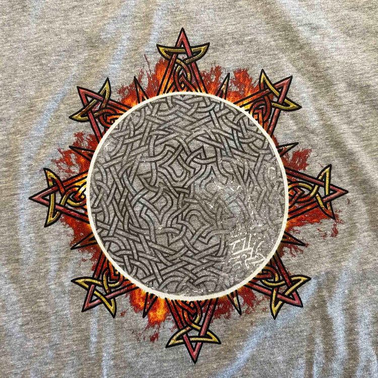 A close-up view of an athletic heather Xigfireon long sleeve graphic tee featuring the Eclipsed iteration of the `Morning Star Fire` Celtic knot design, inspired by the 2023 Annular Solar Eclipse.