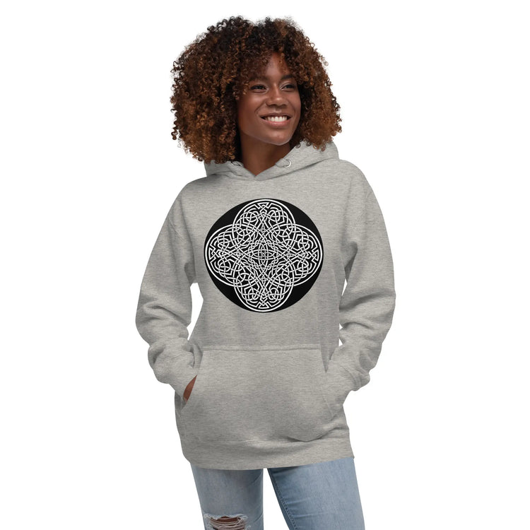 A young woman wearing a carbon grey Xigfireon graphic hoodie featuring the Black & White Circle iteration of the `Reach Of The Spirit` Celtic knot design. The `Reach Of The Spirit` Celtic knot represents the Earth.