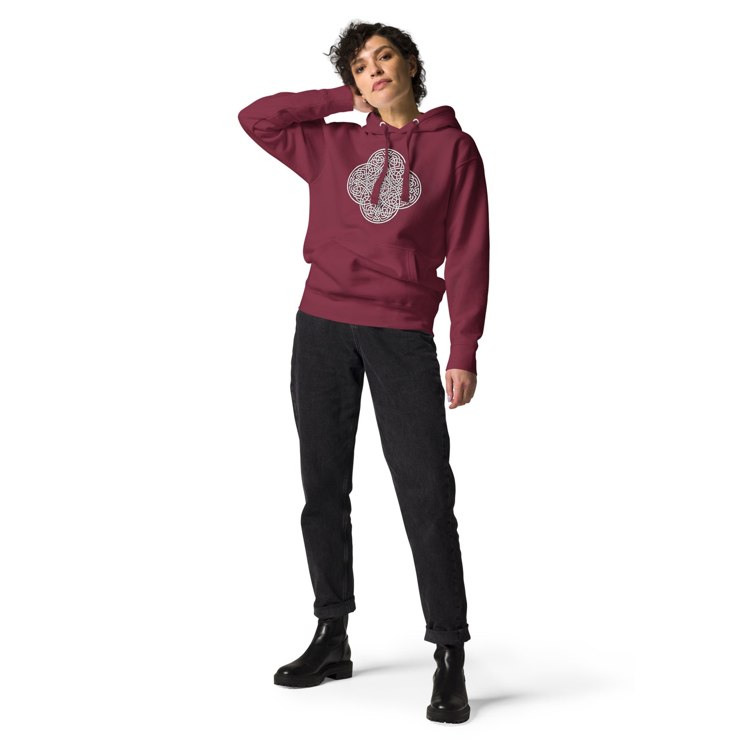 A young woman wearing a maroon Xigfireon graphic hoodie featuring the Black & White Hollow iteration of the `Reach Of The Spirit` Celtic knot design. The `Reach Of The Spirit` Celtic knot symbolizes the Earth.