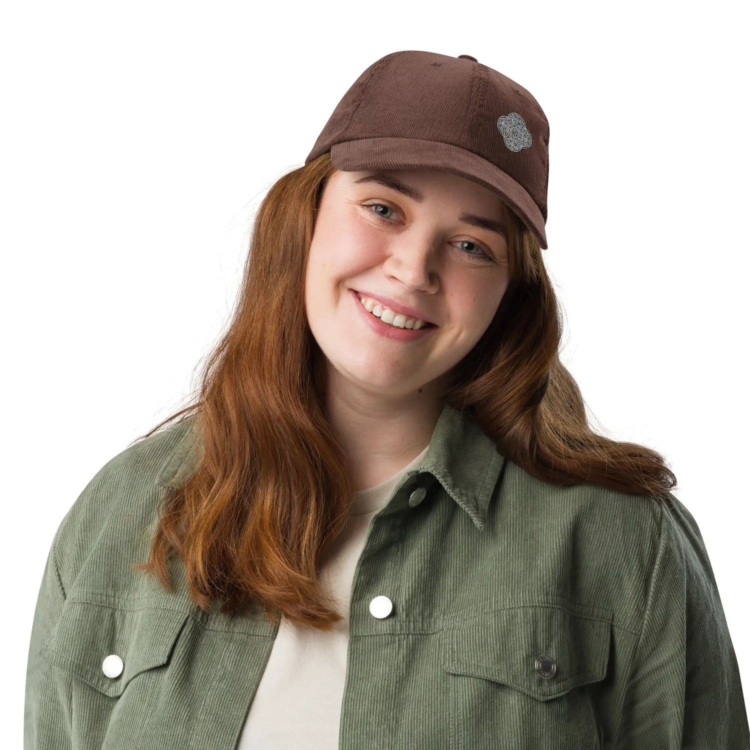 A young woman wearing a brown Xigfireon vintage corduroy cap embroidered with the Black & White Solid iteration of the `Reach Of The Spirit` Celtic knot design offset to the left.