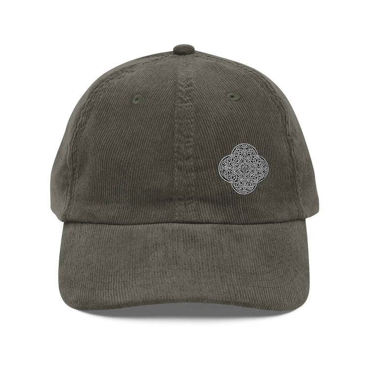 The front side of an olive green Xigfireon vintage corduroy cap embroidered with the Black & White Solid iteration of the `Reach Of The Spirit` Celtic knot design offset to the left.